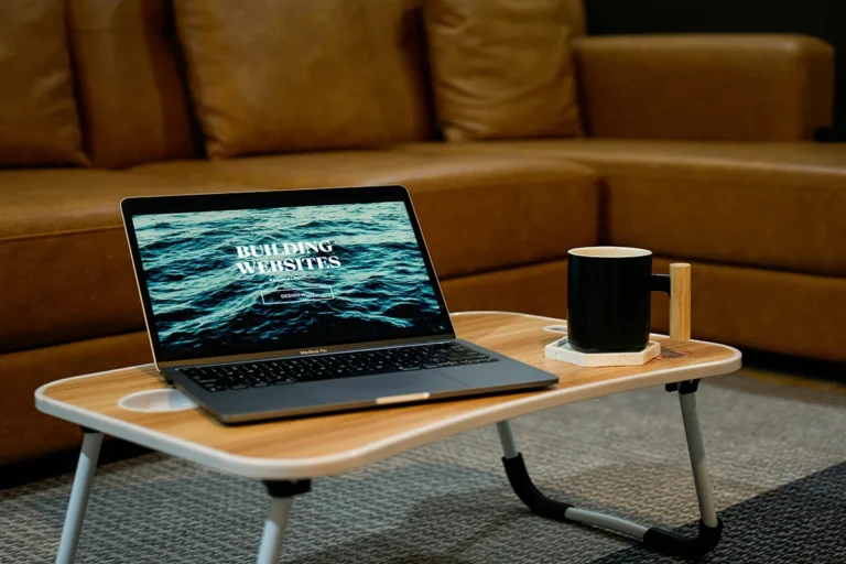 Α laptop sitting on top of a wooden table.