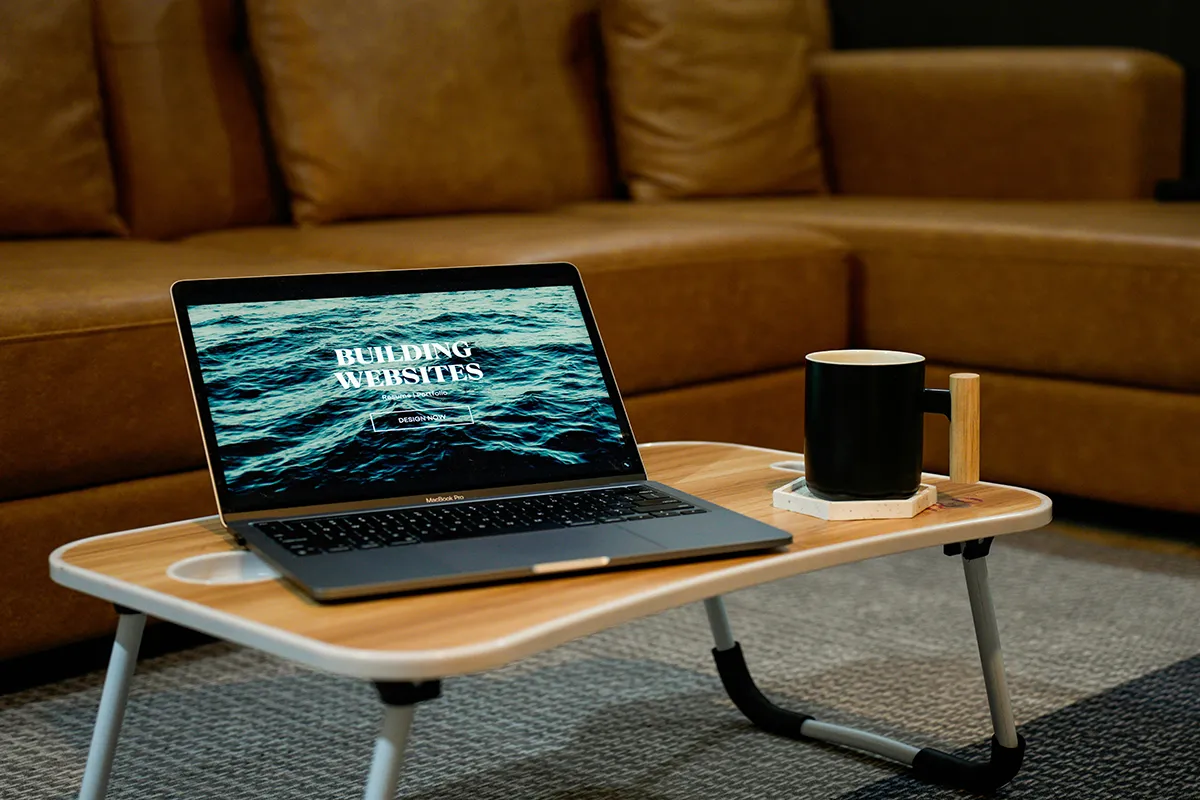 Α laptop sitting on top of a wooden table.