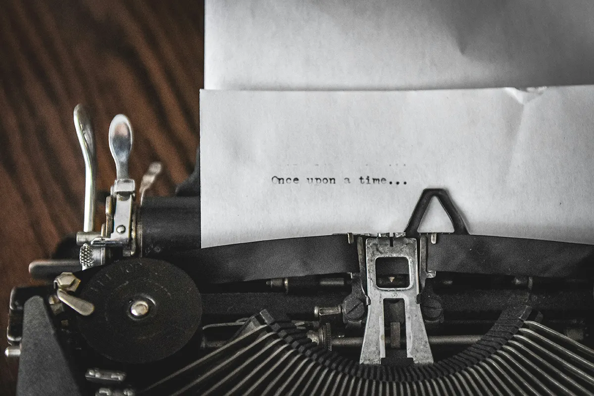 A vintage typewriter and a piece of paper with the words: Once upon a time.