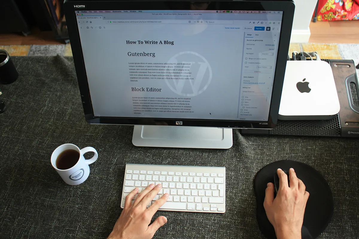 A man is typing on his computer. On the screen, there's an article with the title How To Write a Blog, which fits with our article about why every hotel website needs a blog.