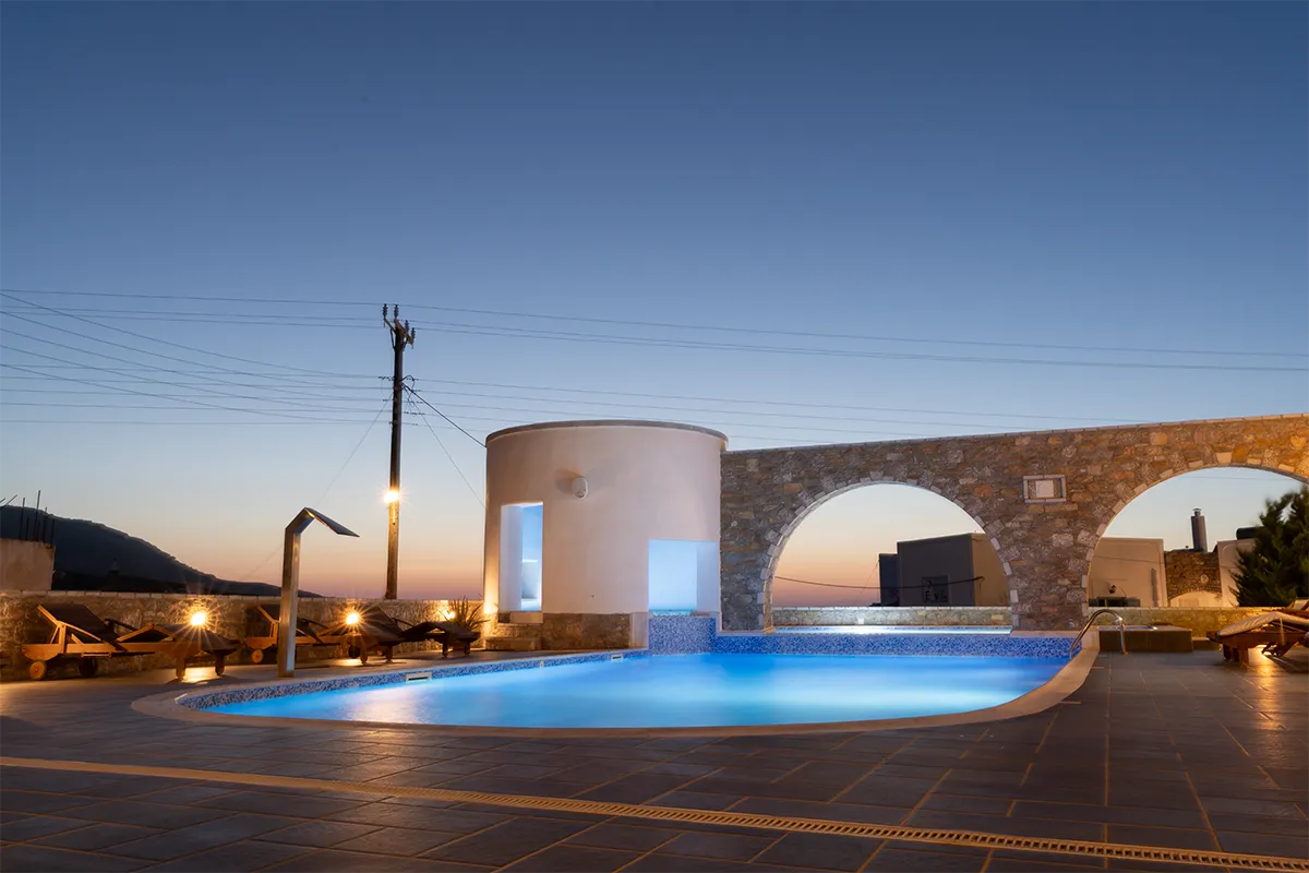 The pool area of a hotel at dusk.