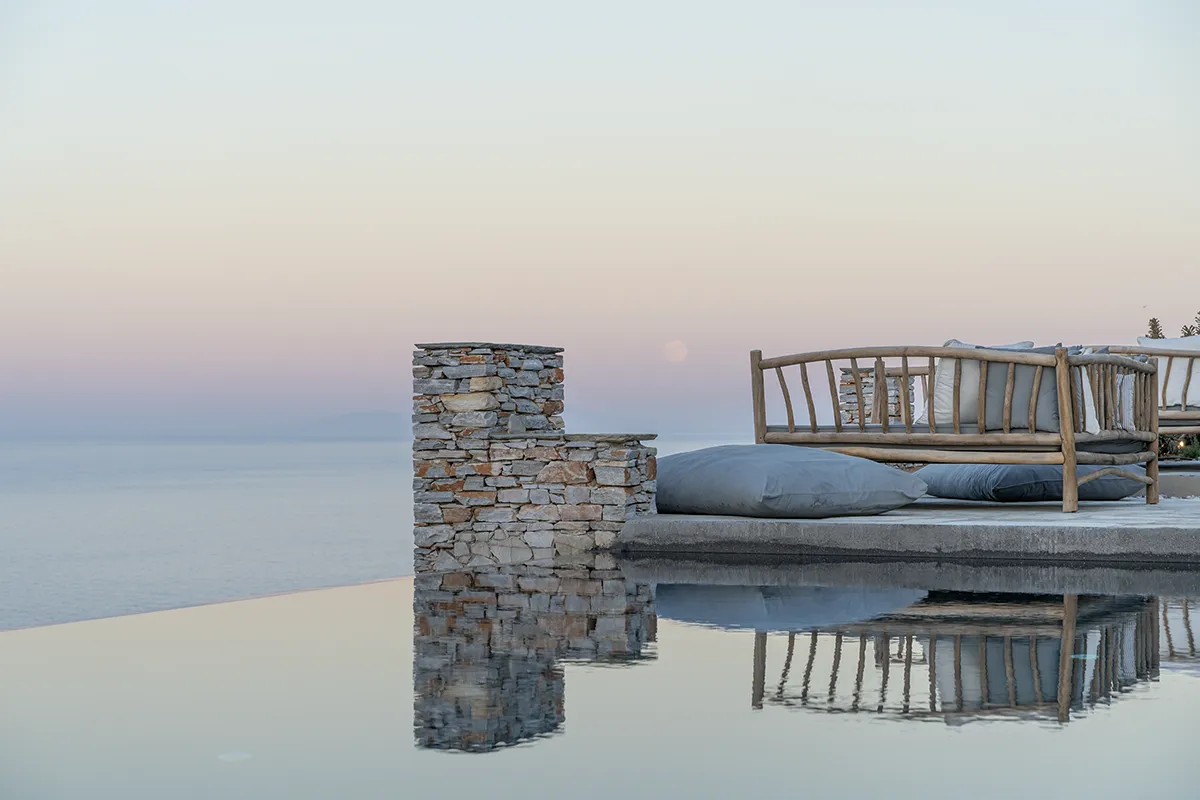 An infinity pool with the sun rising in the background.